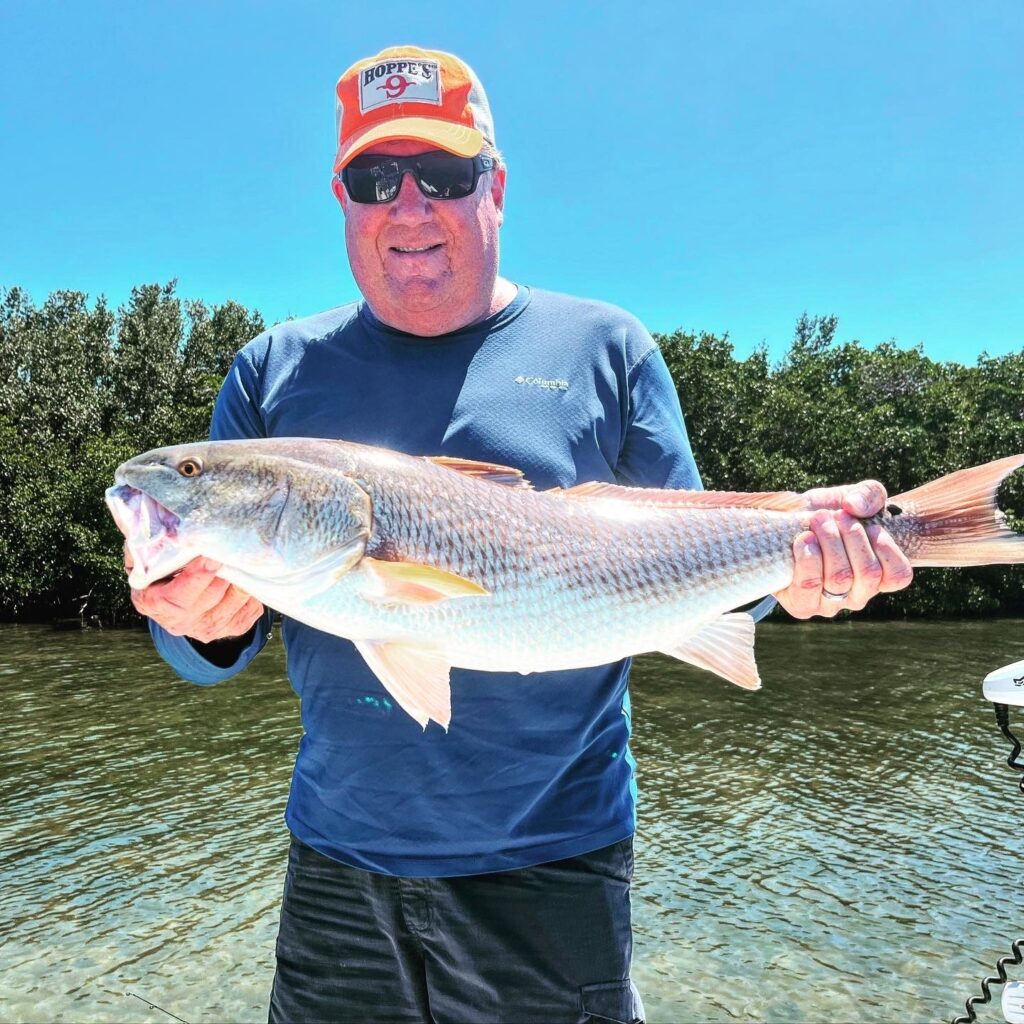 Man in Columbia Shirt with Big Red Fish Cape Coral Charter Fishing